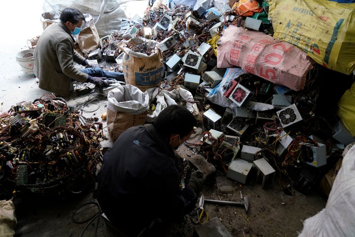 Workers dismantle electronic waste in Guiyu, Guangdong Province, China. 