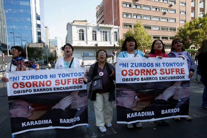 People hold banners reading "Neither lefties nor fools, Osorno suffers, Bishop Barros, accessory after the fact," during a protest in Chile on January 16, 2018. 