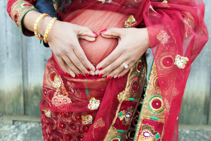 Sherine Valverde wore a red sari for the first half of her maternity shoot.