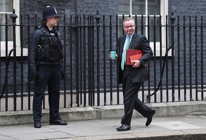 Environment Secretary Michael Gove holds a reusable coffee cup as he arrives in Downing Street, London.