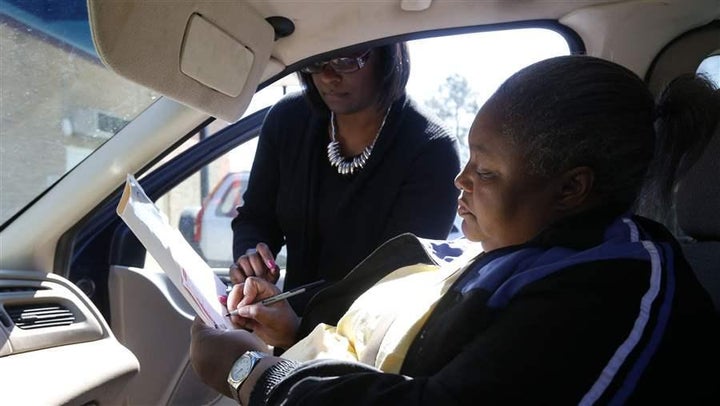 <p>A South Carolina voter, prevented from entering a polling place by her physical disability, receives assistance from a poll worker on the day of the state’s 2016 Democratic presidential primary. More people with disabilities are encountering barriers to voting, a problem that is being exacerbated by the widespread return to paper ballots.</p>