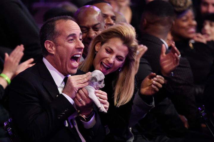 Jerry and Jessica Seinfeld hold a puppy during the Grammy Awards at Madison Square Garden.