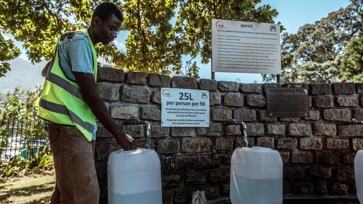 Cape Town residents fill water bottles after waiting in line at Newlands Brewery Spring Water Point on Tuesday.