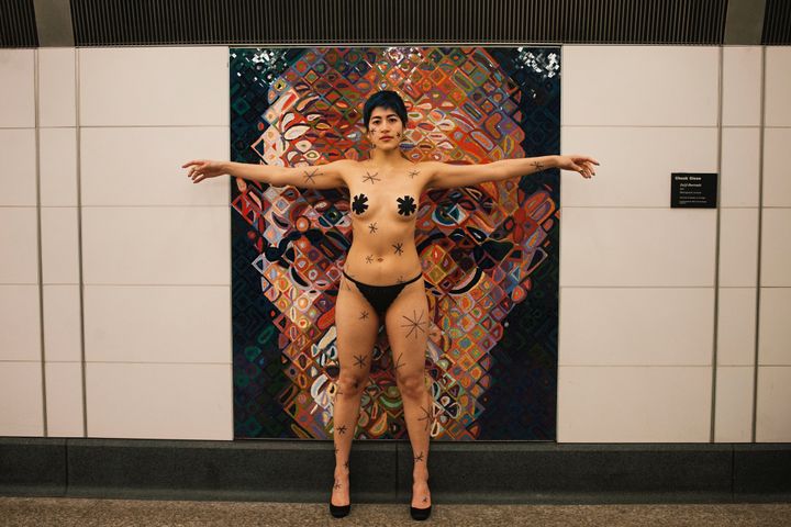 Performance artist Emma Sulkowicz protests Chuck Close's artwork in the 86th Street subway station in New York by providing their own asterisks on Jan. 30.