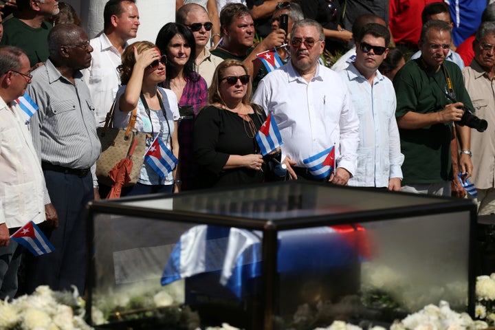 Diaz-Balart (fourth from R, holding flag) joins people lining a street to watch as the caravan carrying the ashes of Fidel Castro arrives in Santiago de Cuba, Cuba, in December 2016