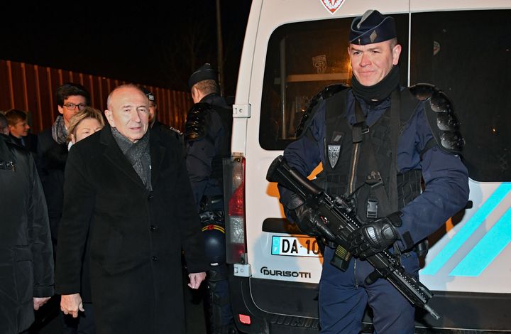 French Interior Minister Gerard Collomb walks near a gendarme during a visit to Calais on February 2