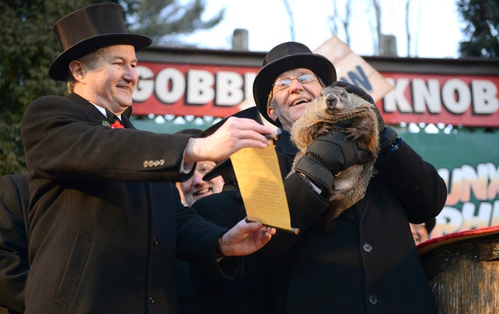 Groundhog Club Vice President Jeff Lundy, left, shares Punxsutawney Phil's prediction with co-handler Ron Ploucha at the 2016