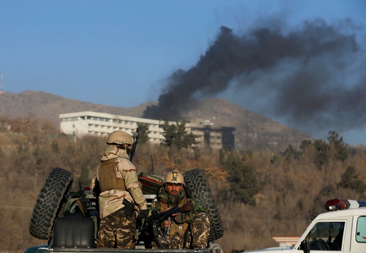 Afghan security forces look on as smoke rises from the Intercontinental Hotel in Kabul on Jan. 21, 2018.