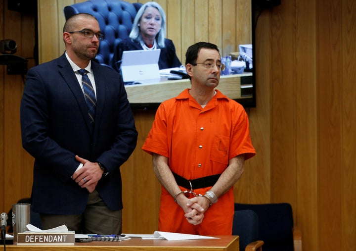 Larry Nassar stands with his attorney Matt Newburg as Judge Janice Cunningham (seen on screen) gives instructions during Nassar's second sentencing in the Eaton County Circuit Court in Charlotte, Michigan, U.S., January 31, 2018.