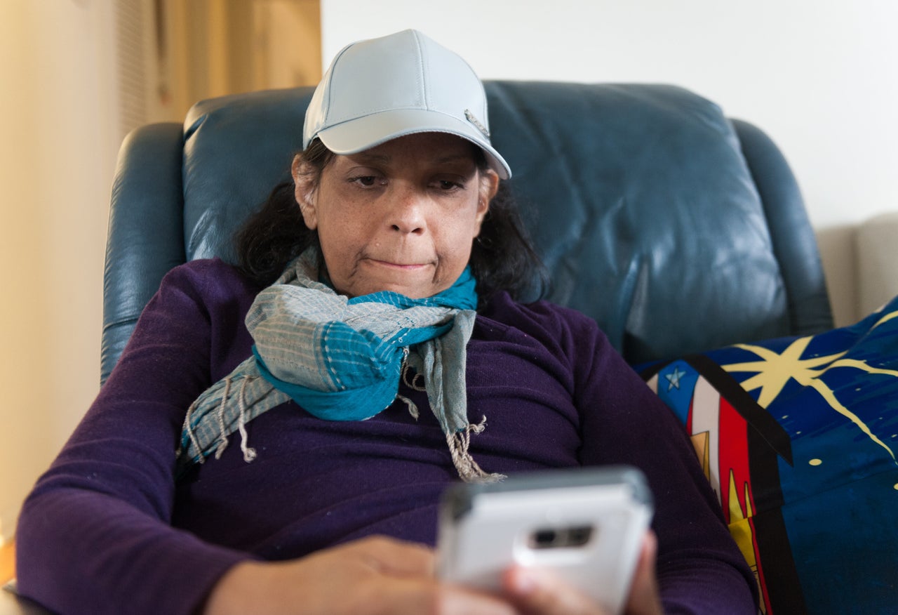 Mariluz Núñez looks at family photos while staying at the temporary apartment in Orlando