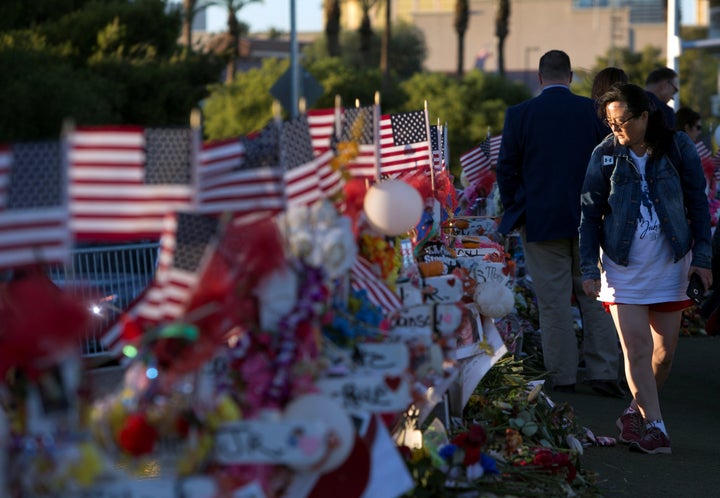 Terri Xiang of Texas looks over 58 wood crosses with the names and photos of the Las Vegas shooting victims.