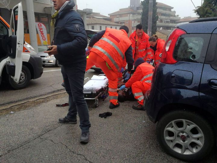 Paramedics treat an injured person who was shot from a passing vehicle in Macerata, Italy