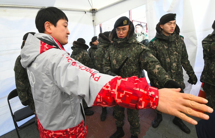 Soldiers inspect a visitor at a checkpoint after they replaced 1,200 civilian security guards amid a norovirus outbreak.