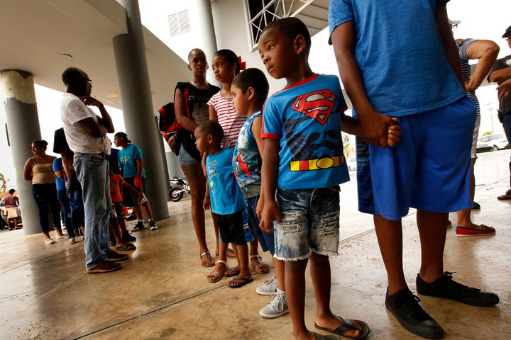  Members of the Pisaro family of four children, wait in line for FEMA food distribution in the town of Rio Grande on Sept. 27, 2017. 