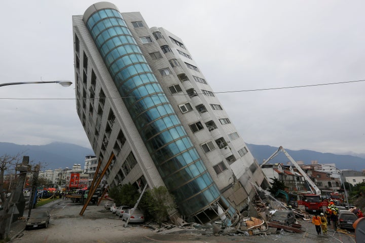 Rescue workers are seen by a damaged building after an earthquake hit Hualien, Taiwan February 7, 2018.