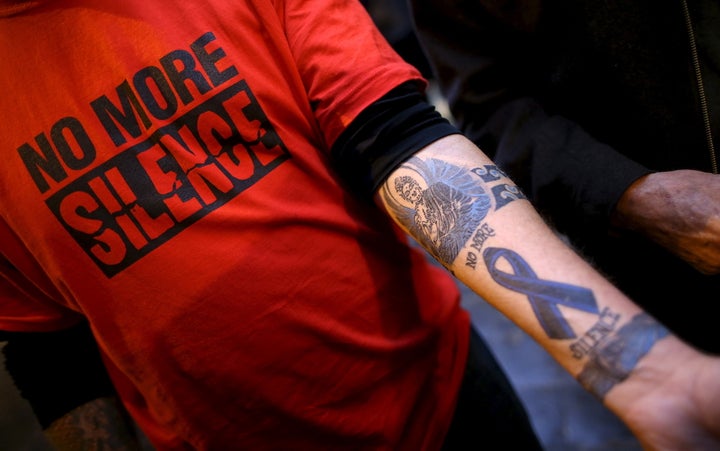 Paul Levely, a child sex abuse victim, wears a T-shirt that says "No more silence" and shows a tattoo in Rome in 2016 as Aust