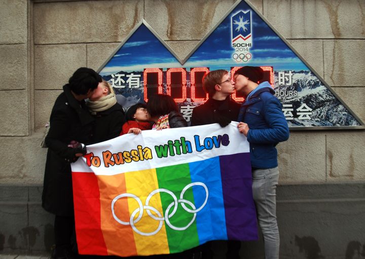 A group of gay and lesbian activists hold a banner of the rainbow flag, the Olympic rings and the words 'To Russia with love' as they stage a Valentine's Day kissing protest in Beijing on Feb. 14, 2014.