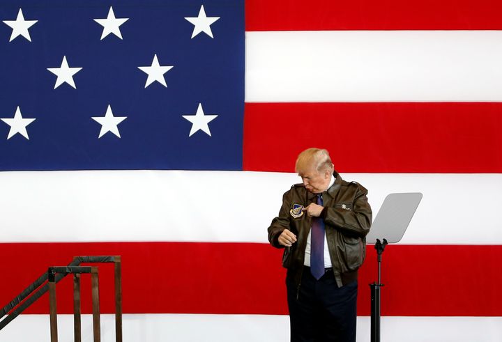 President Donald Trump points to a detail on his flight jacket while on stage at a U.S. Air Force base on the outskirts of Tokyo, Japan, on Nov. 5, 2017.