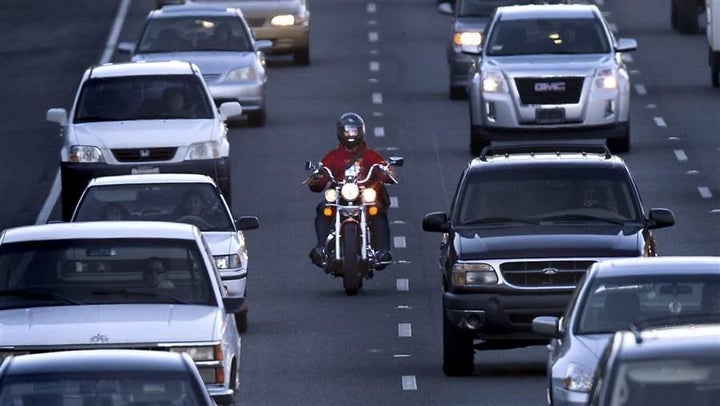 <p>A motorcyclist splits a lane on Highway 99 in Sacramento, California. Other states could follow California in legalizing lane-splitting.</p>