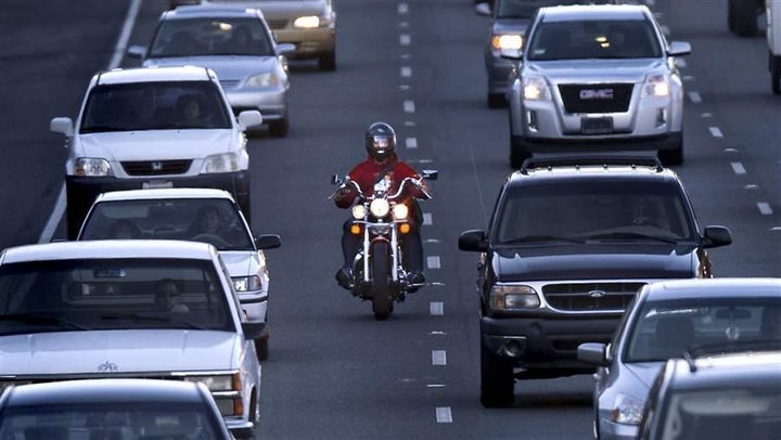 A motorcyclist splits a lane on Highway 99 in Sacramento, California. Other states could follow California in legalizing lane-splitting.