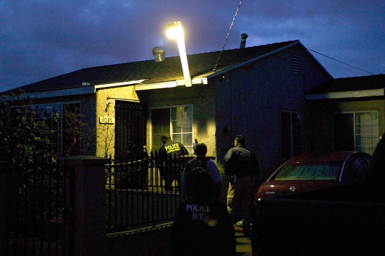 U.S. Immigration and Customs Enforcement agents approach a house in the pre-dawn hours to make an arrest in San Diego in 2006. (File photo)