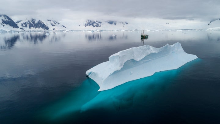 The Greenpeace ship Arctic Sunrise near an iceberg in Charlotte Bay in the Antarctic Ocean.