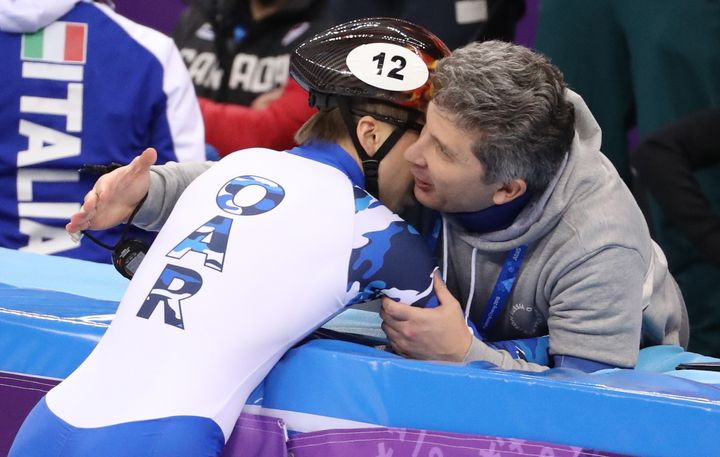 Elistratov hugs a man in the stands at the speed skating event.