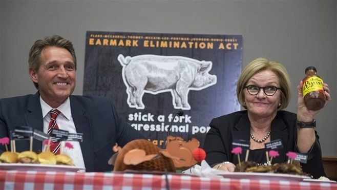 U.S. Sens. Jeff Flake, an Arizona Republican, and Claire McCaskill, a Missouri Democrat, eat barbecue during an event in Congress to introduce the Earmark Elimination Act to demonstrate that Congress can “eat pork without spending it.”