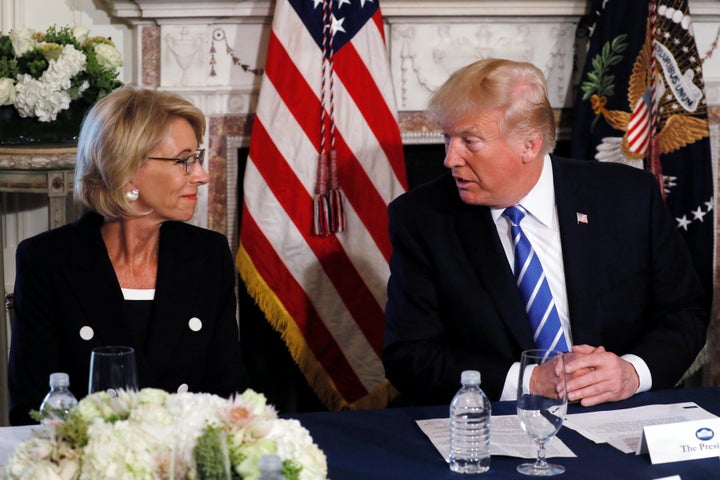 U.S. President Donald Trump turns to Education Secretary Betsy DeVos (L) during his remarks to reporters before a workforce apprenticeship discussion at Trump's golf estate in Bedminster, New Jersey U.S. August 11, 2017. REUTERS/Jonathan Ernst