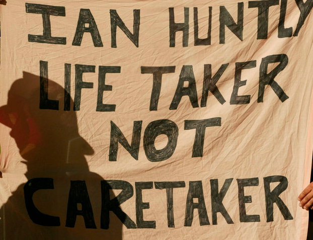 Protesters hold up a banner as Ian Huntley arrived at court to face murder charges in 2002 