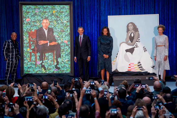 The crowd takes their own pictures of Kehinde Wiley, Barack Obama, Michelle Obama, Amy Sherald and the two portraits.