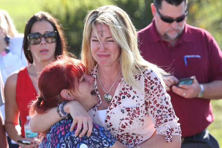 Parents wait for news after reports of a shooting at Marjory Stoneman Douglas High School in Parkland, Florida, on Wednesday. One woman's forehead is marked from an Ash Wednesday ritual.