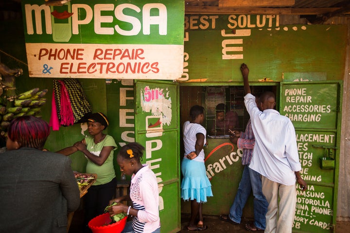 Residents transfer money using the M-Pesa banking service at a store in Nairobi, Kenya.