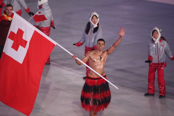 Flag bearer Pita Taufatofua of Tonga leads the team as they parade around the arena during the opening ceremony.
