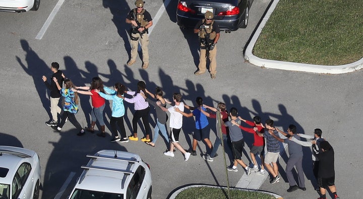 Students evacuate Marjory Stoneman Douglas High School, in Parkland, Florida, after a shooting there killed numerous people on Feb. 14, 2018.