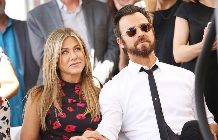 Jennifer Aniston and Justin Theroux sit together at the Hollywood Walk of Fame on July 26, 2017.