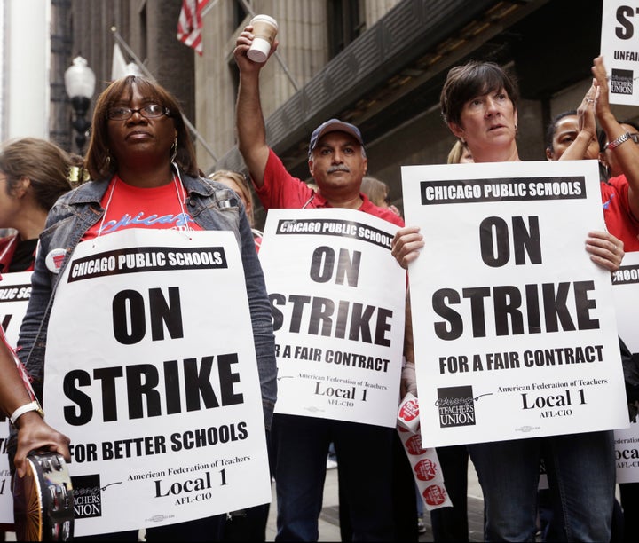 Chicago Teachers Union members listen to an update about negotiations on the fourth day of their strike on Sept. 13, 2012.