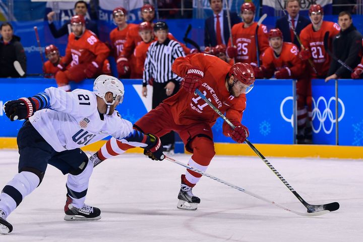 James Wisniewski and Sergei Andronov fight for the puck in Saturday's hockey match between the U.S. and the Olympic Athletes from Russia.