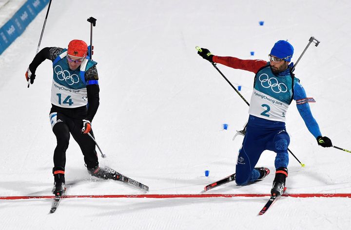 Simon Schempp of Germany, left, and Martin Fourcade of France, right, race to the finish line during Sunday's Men's 15 km Mass Start Final.