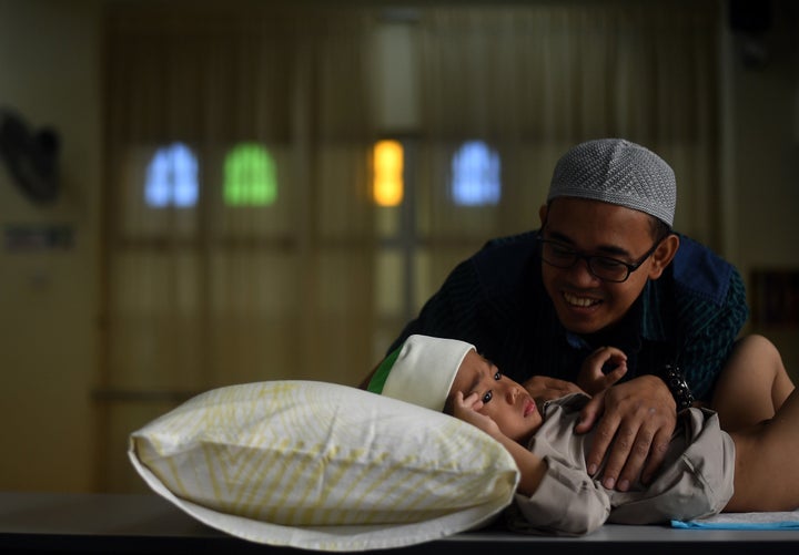 A four-year-old Muslim boy is comforted by his father before being circumcised during a ceremony at a mosque in Kuala Lumpur, Malaysia.