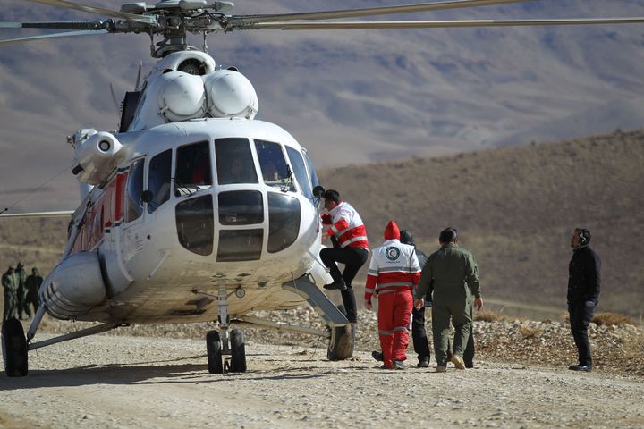 Members of emergency and rescue team search for the plane that crashed in a mountainous area of central Iran.