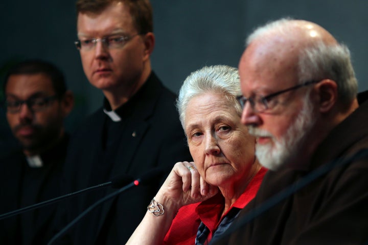 Marie Collins (second from right) watches as Cardinal Sean Patrick O'Malley (right) speaks during a briefing o