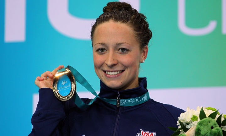 Ariana Kukors holds up her gold medal after winning the women's 100-meter individual medley on day three of the World Sw