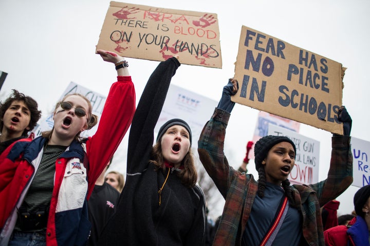 Protesters hold signs during the demonstration against gun violence.