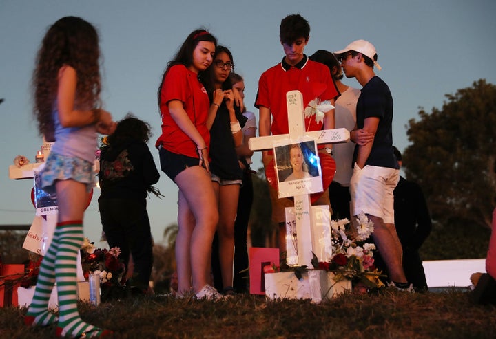 People visit a makeshift memorial at Marjory Stoneman Douglas High School on Sunday in Parkland, Florida, where 17 adults and