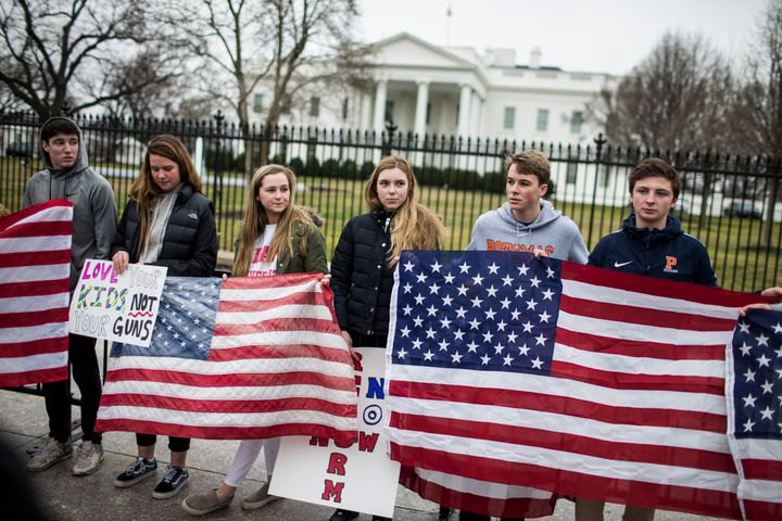 Demonstrators hold flags during a "die-in" protest near the White House on Monday. High school students gathered to push for gun control after last week's deadly school shooting in Parkland, Florida.