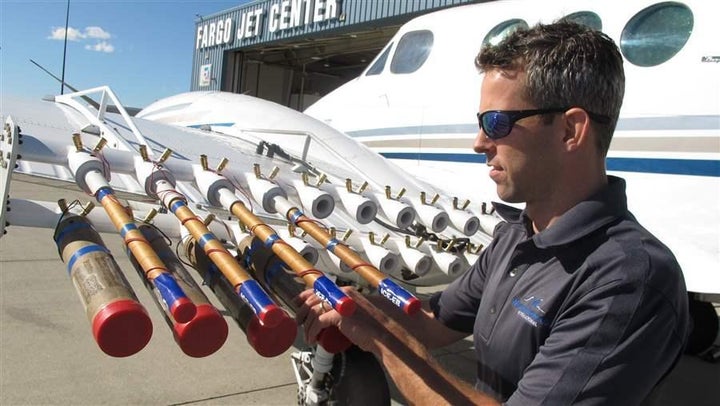 Jody Fischer, director of flight operations for Weather Modification Inc., adjusts flares for seeding on a plane outside the