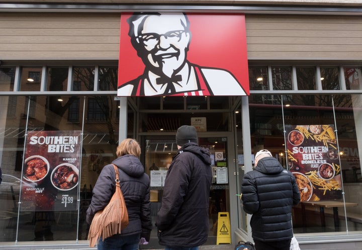 People look into a closed KFC restaurant in Bristol, England, on Tuesday.