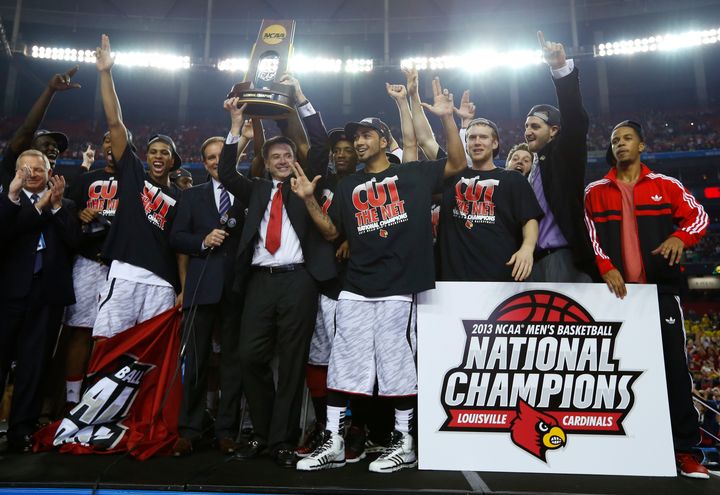 University of Louisville head basketball coach Rick Pitino hoists the trophy after his team defeated the University of Michigan in the NCAA men's Final Four championship basketball game in 2013. Pitino has since been fired amid scandals surrounding the school's basketball program.