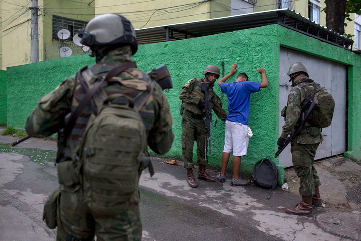 Brazilian army members stop and frisk a resident of the Cidade de Deus favela in Rio de Janeiro, during a security operation in February. 